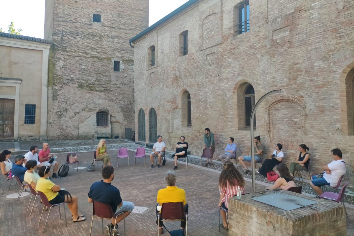 partecipanti all'incontro seduti in cerchio nel cortile interno della Rocca