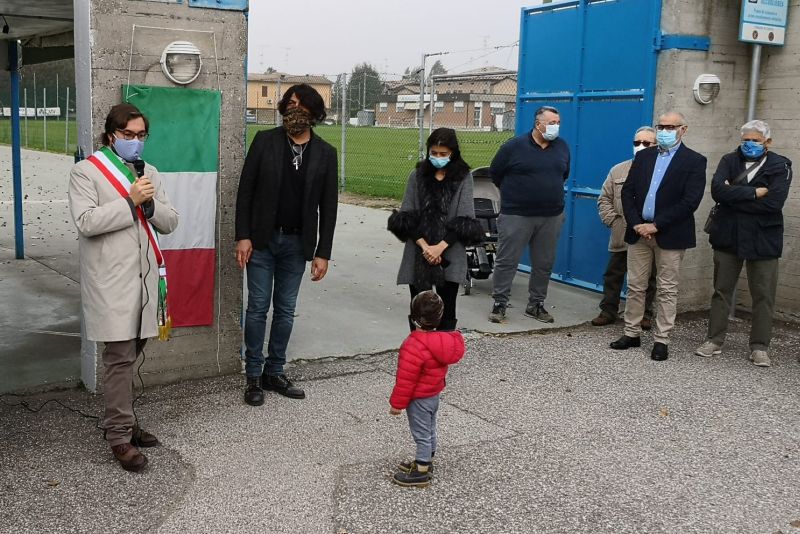parla al microfono il vicesindaco alla presenza di Gianno Govoni e famiglia davanti al campo sportivo con la targa intitolazione scoperta